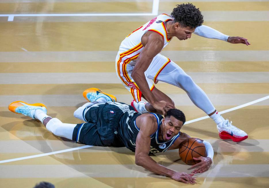 Milwaukee Bucks forward Giannis Antetokounmpo (34) dives for a loose ball stolen from Atlanta H ...