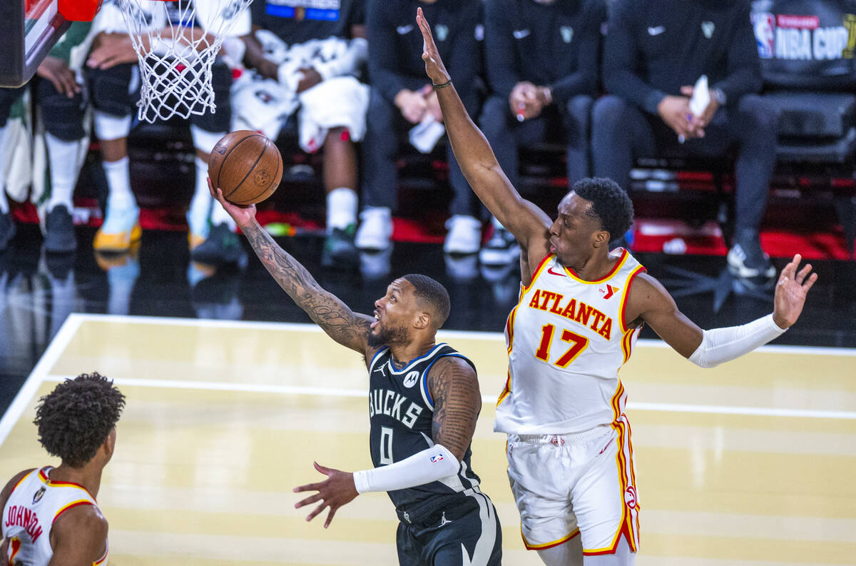 Milwaukee Bucks guard Damian Lillard (0) gets underneath Atlanta Hawks forward Onyeka Okongwu ( ...