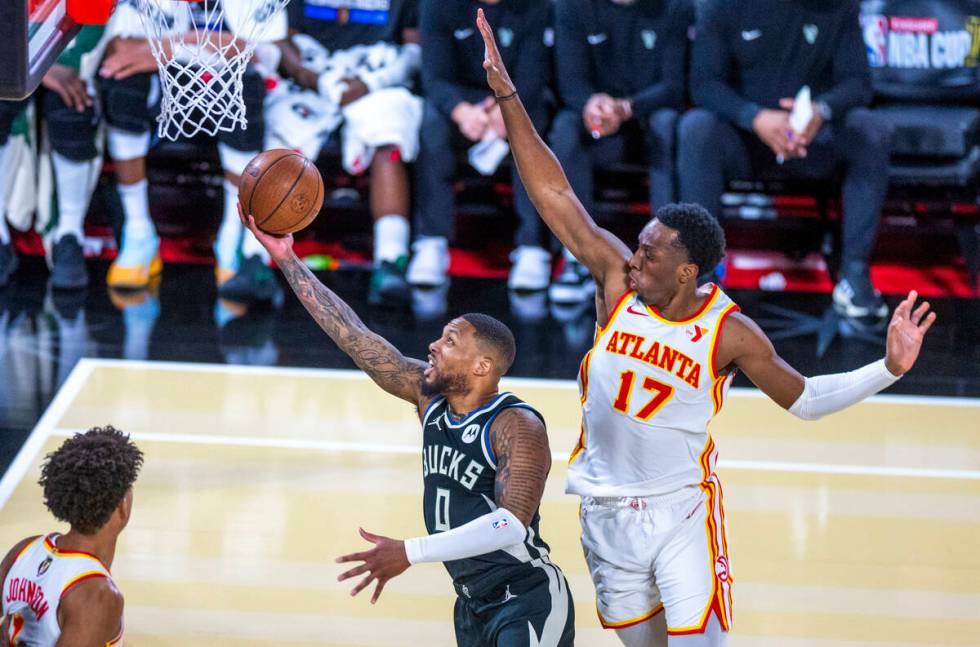 Milwaukee Bucks guard Damian Lillard (0) gets underneath Atlanta Hawks forward Onyeka Okongwu ( ...