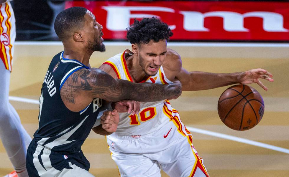 Milwaukee Bucks guard Damian Lillard (0) fouls Atlanta Hawks forward Zaccharie Risacher (10) on ...