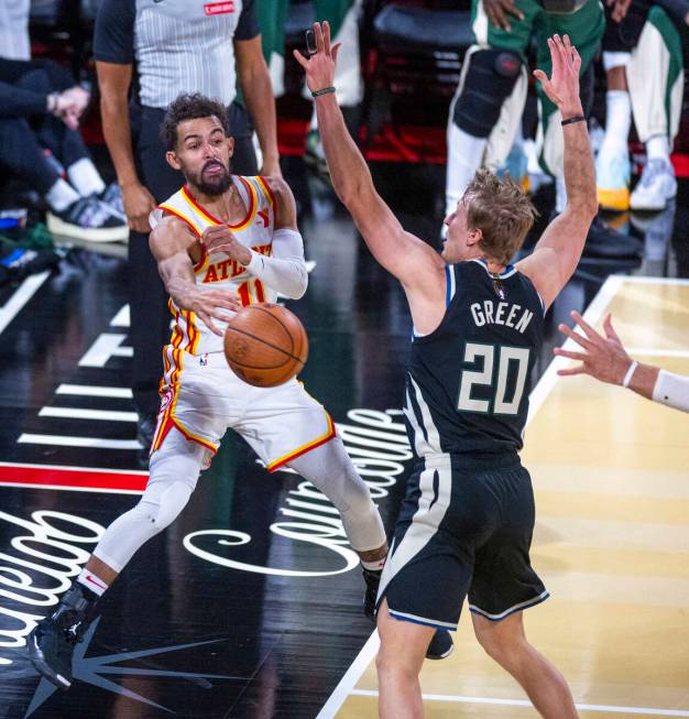 Atlanta Hawks guard Trae Young (11) passes while moving out of bounds past Milwaukee Bucks guar ...