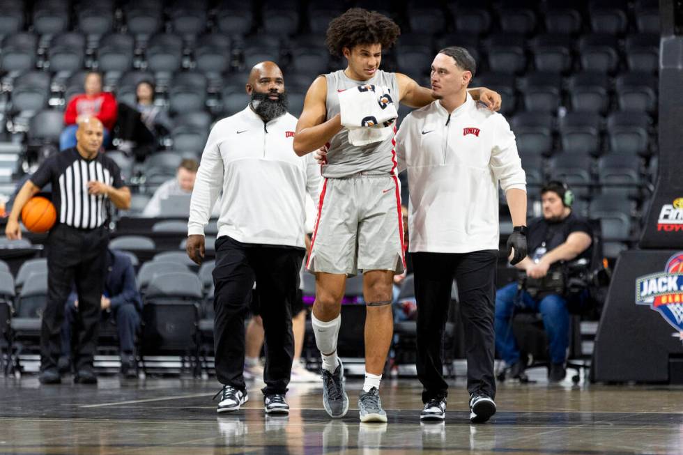 UNLV forward Jalen Hill, center, is helped off the court after taking a blow to the face during ...