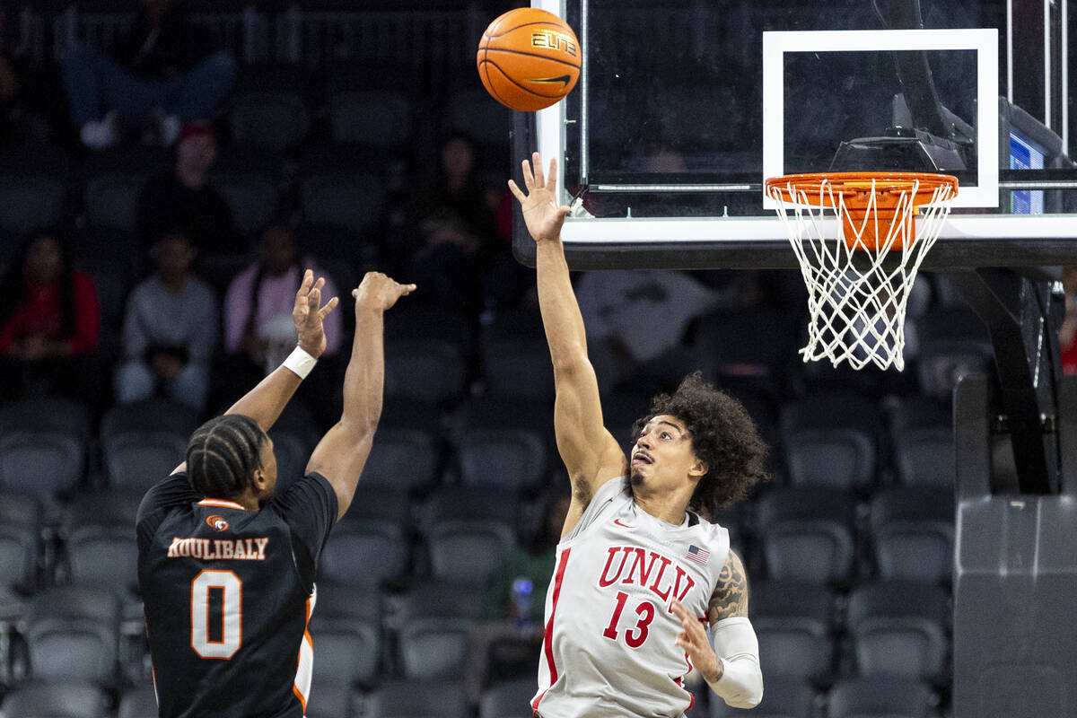 UNLV guard Brooklyn Hicks (13) attempts to block a shot by Pacific Tigers guard Jefferson Kouli ...