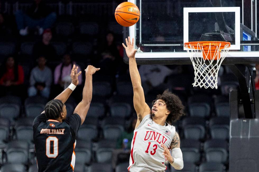 UNLV guard Brooklyn Hicks (13) attempts to block a shot by Pacific Tigers guard Jefferson Kouli ...