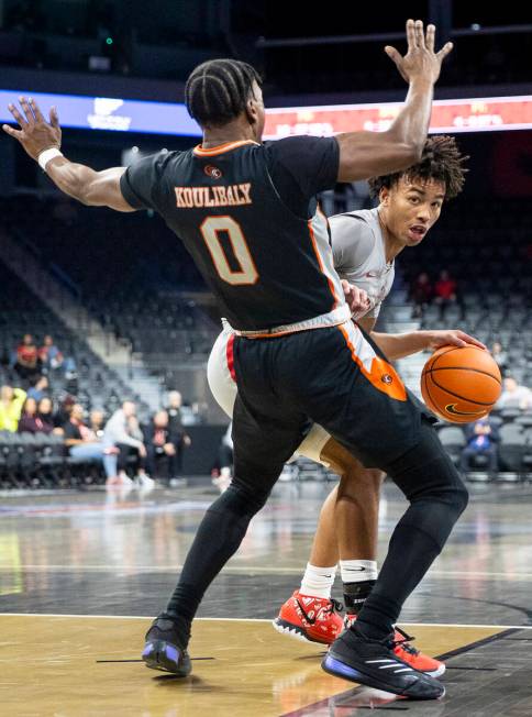 UNLV guard Dedan Thomas Jr., back, looks to pass Pacific Tigers guard Jefferson Koulibaly (0) d ...