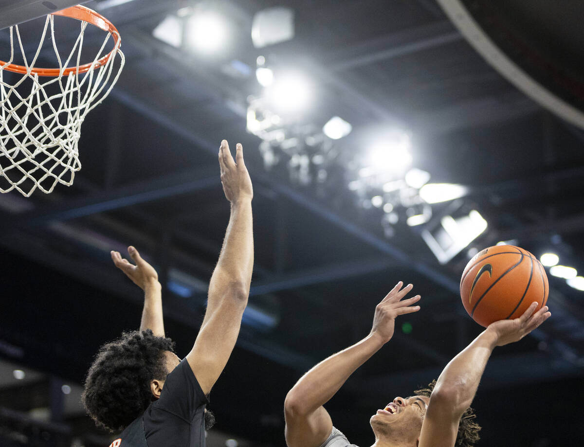 UNLV guard Dedan Thomas Jr., right, attempts a shot over Pacific Tigers center Jazz Gardner, le ...