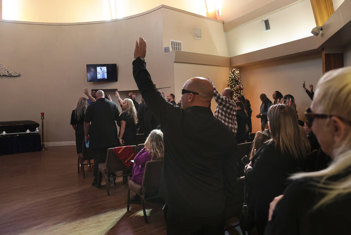 People stand and raise their hands when asked by Minister Vance “Stretch” Sanders if Brando ...