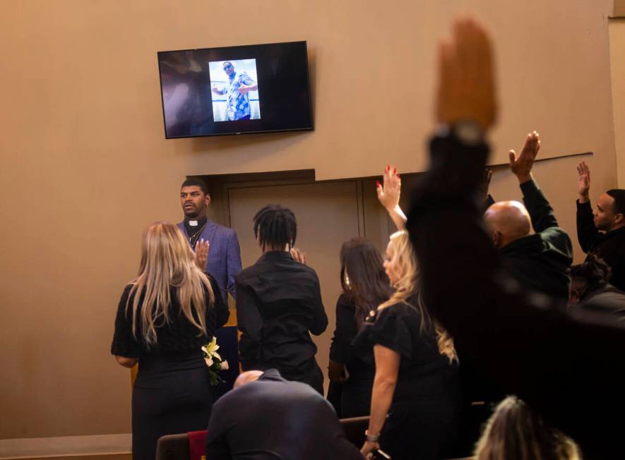 People raise their hands in response to a question during the funeral service for Brandon Durha ...