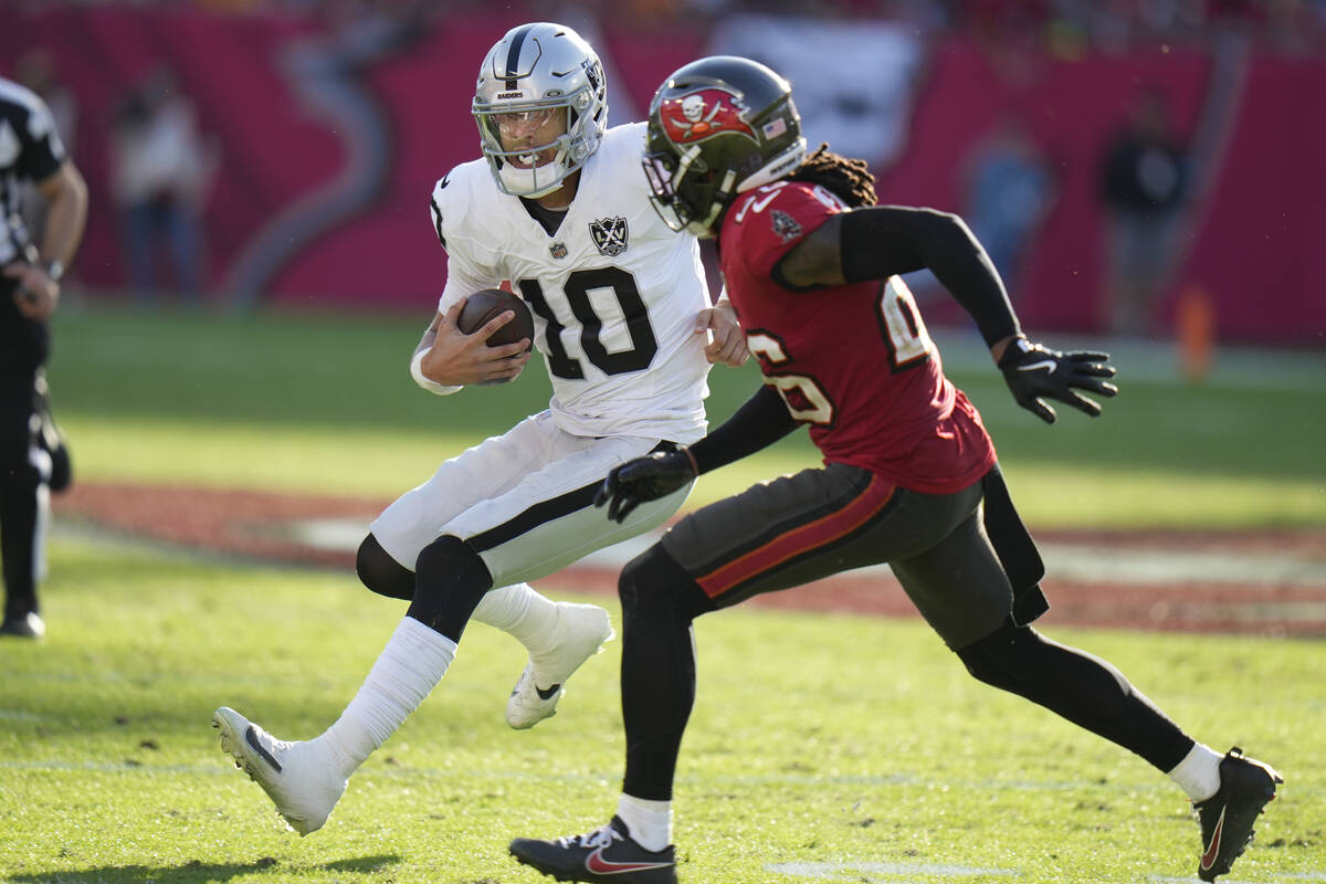 Las Vegas Raiders quarterback Desmond Ridder (10) tries to get around Tampa Bay Buccaneers safe ...