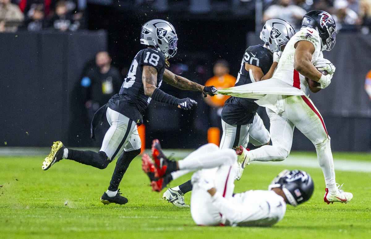 Raiders cornerback Jack Jones (18) grabs apart of the jersey of Atlanta Falcons running back Bi ...