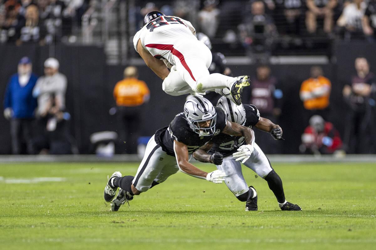 Raiders safety Isaiah Pola-Mao (20) dives after Atlanta Falcons tight end Charlie Woerner (89) ...