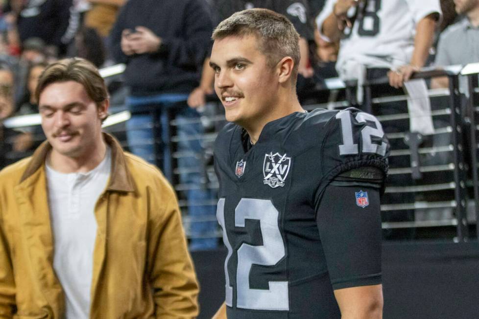 Raiders quarterback Aidan O'Connell (12) on the sideline before the start of an NFL game agains ...