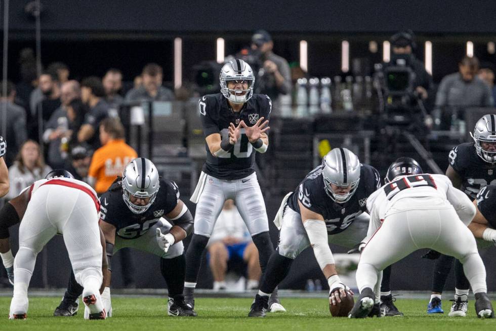 Raiders quarterback Desmond Ridder (10) calls for a hike of the football from guard Jackson Pow ...