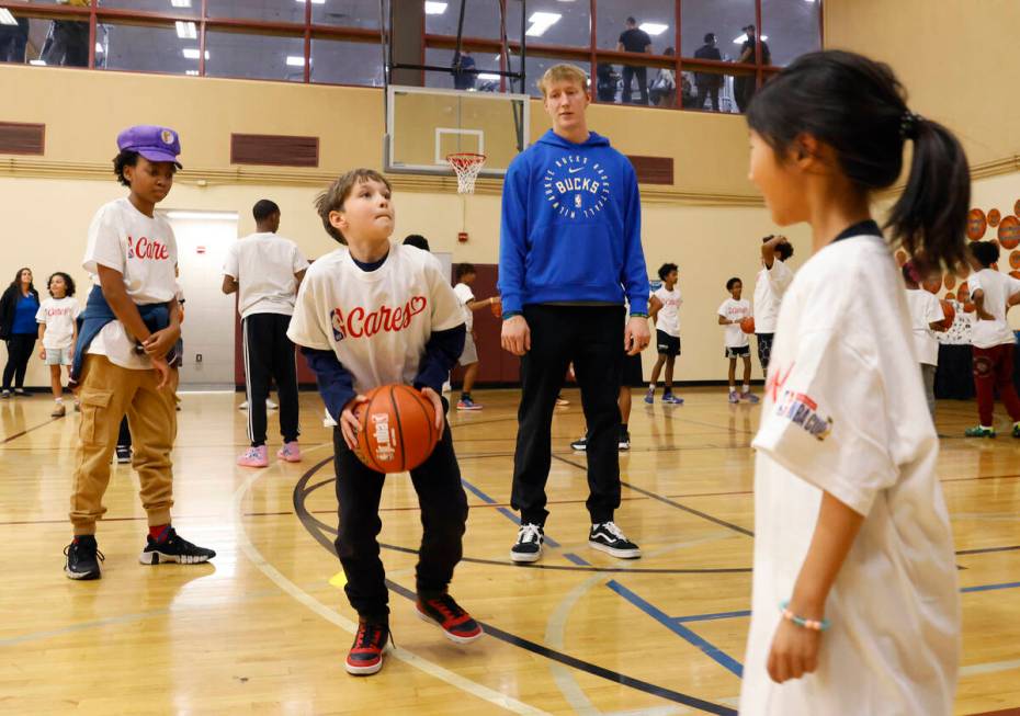 Milwaukee Bucks guard AJ Green, watches as children play basketball during a basketball clinic ...