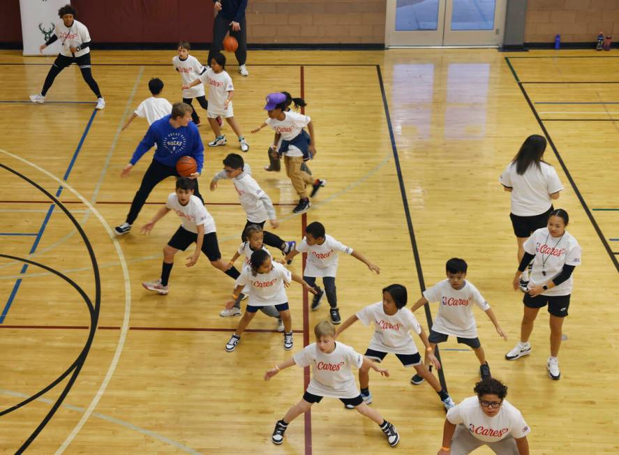 Milwaukee Bucks guard AJ Green, warms up with children during a basketball clinic at Bill and L ...