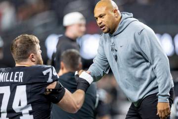 Raiders head coach Antonio Pierce talks to Raiders offensive tackle Kolton Miller (74) before t ...