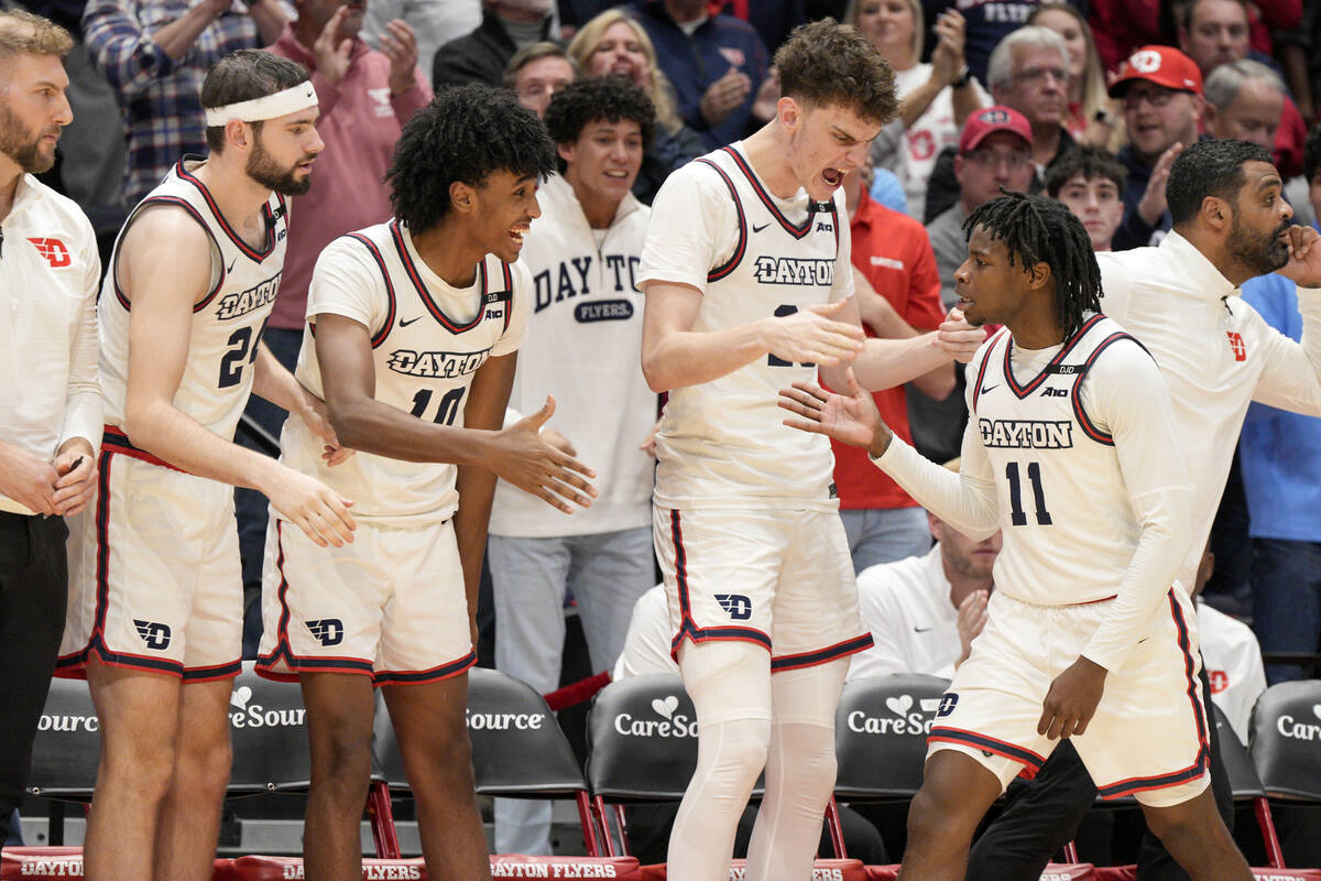 Dayton's Malachi Smith (11) celebrates with teammates after scoring during the second half of a ...