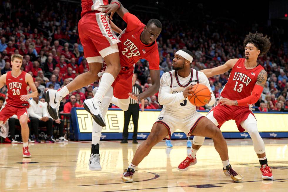 Dayton guard Posh Alexander (5) controls the ball against UNLV's Pape N'Diaye (22) and Brooklyn ...