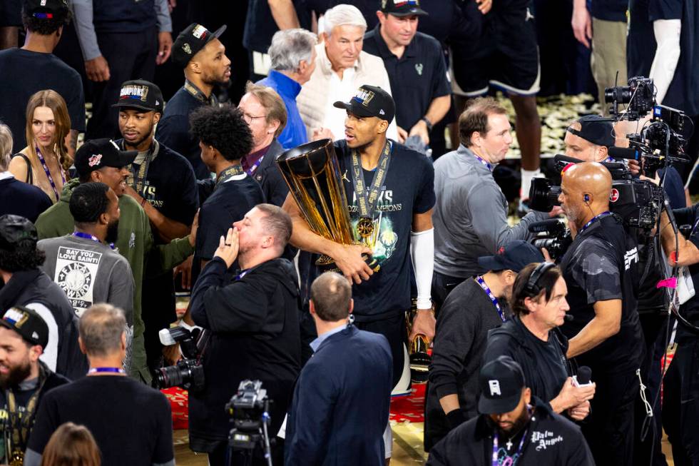 Milwaukee Bucks forward Giannis Antetokounmpo, center, carries the NBA Cup trophy and Most Valu ...