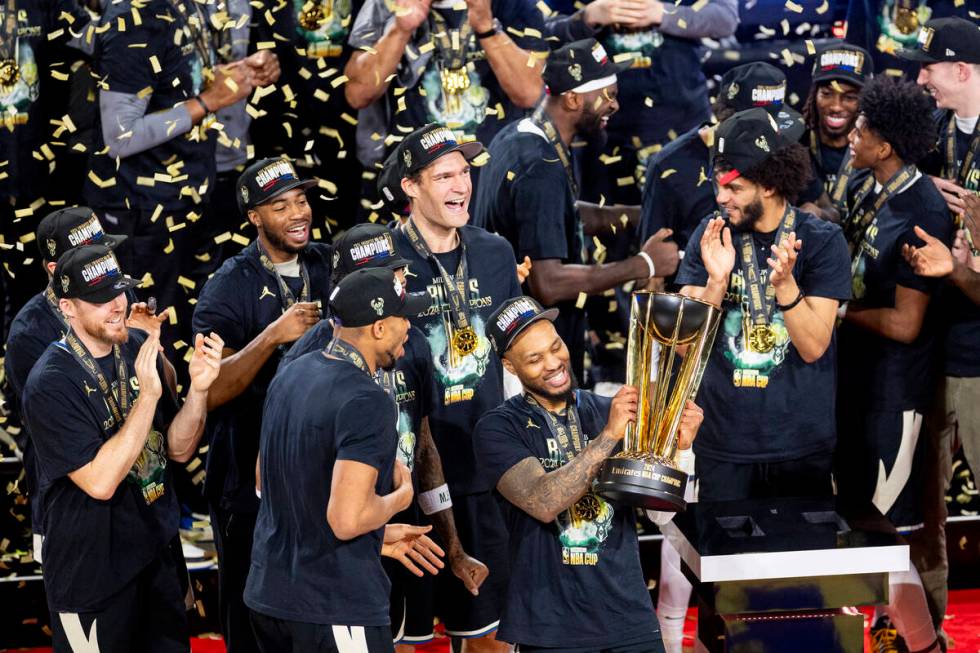 Milwaukee Bucks guard Damian Lillard hoists the NBA Cup trophy after winning the NBA Cup tourna ...