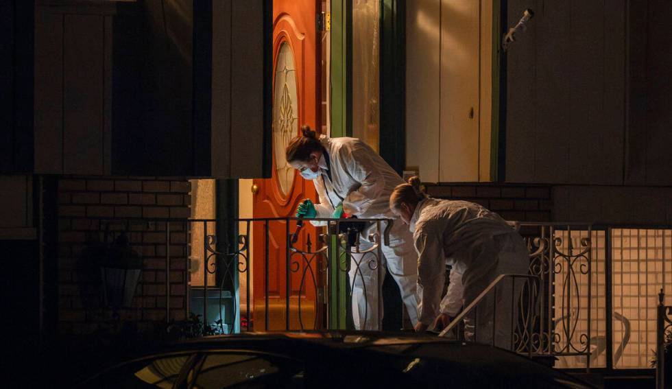 Technicians investigate a crime scene where police say multiple family members were found dead ...