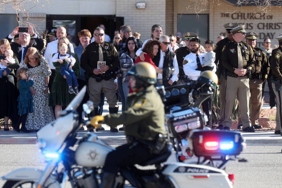 Officers and family members gather at the motorcycle of Las Vegas police officer Colton Pulsiph ...