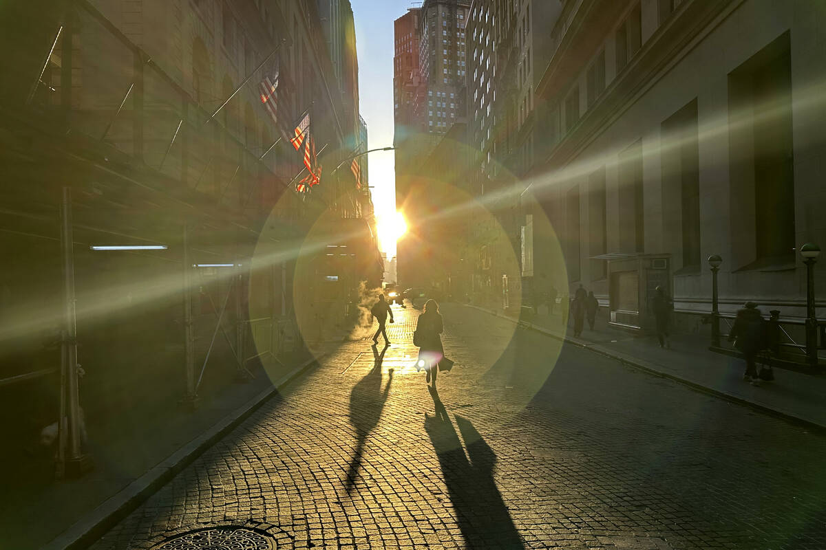 People walk on Wall Street in New York's Financial District on Wednesday, Dec. 18, 2024. (AP Ph ...