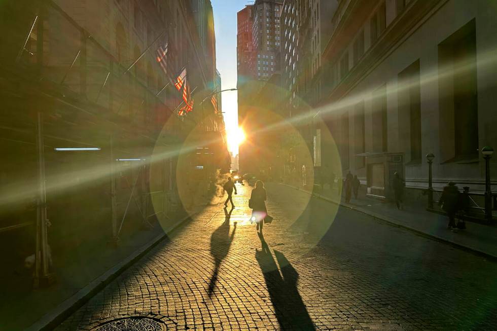 People walk on Wall Street in New York's Financial District on Wednesday, Dec. 18, 2024. (AP Ph ...