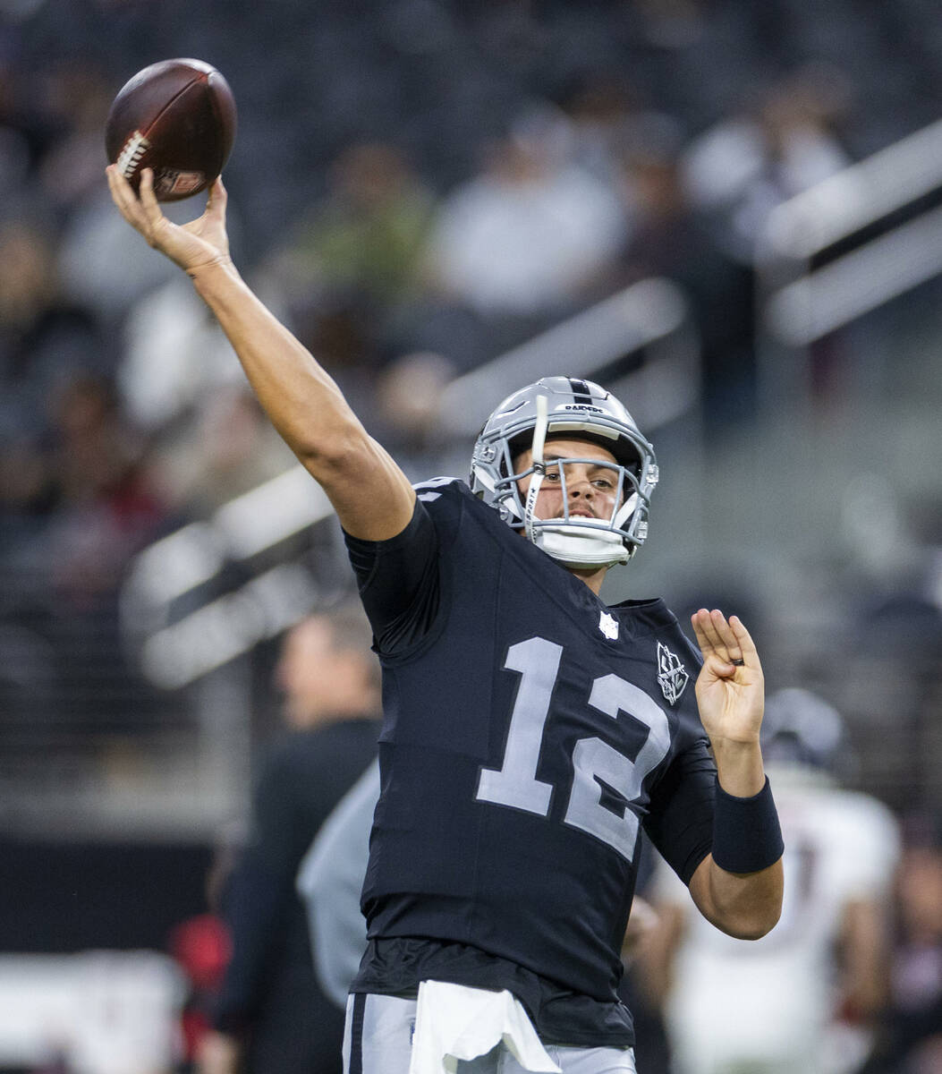 Raiders quarterback Aidan O'Connell (12) gets off a pass during warm ups before the first half ...