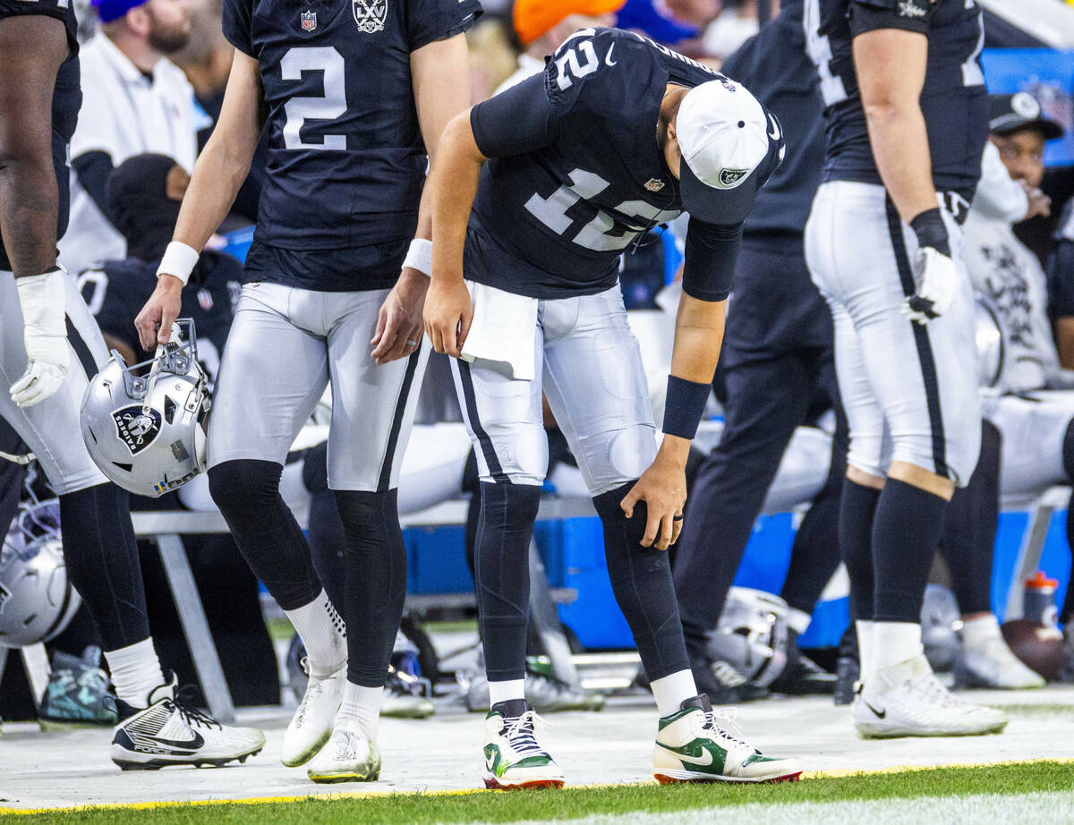 Raiders quarterback Aidan O'Connell (12) massages his knee on the sidelines against the Atlanta ...