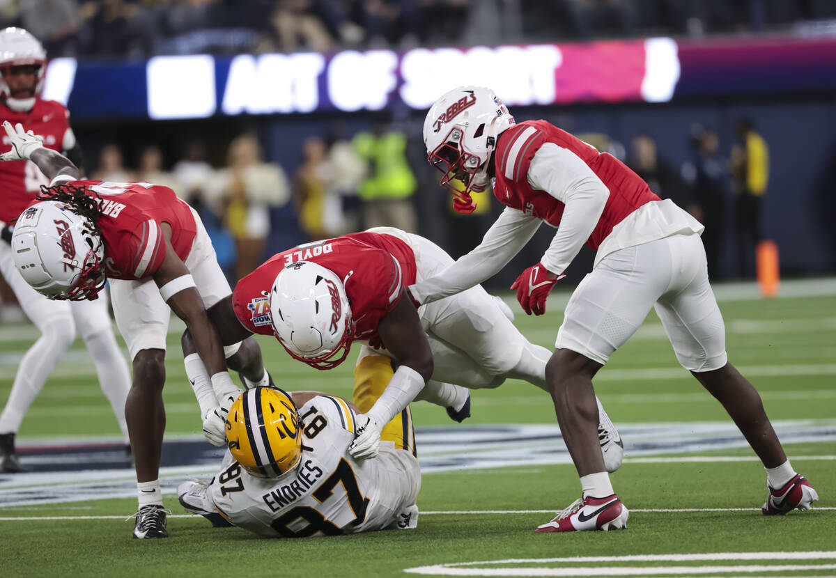 Cal tight end Jack Endries (87) gets tackled by UNLV defensive end Antonio Doyle Jr., center, a ...