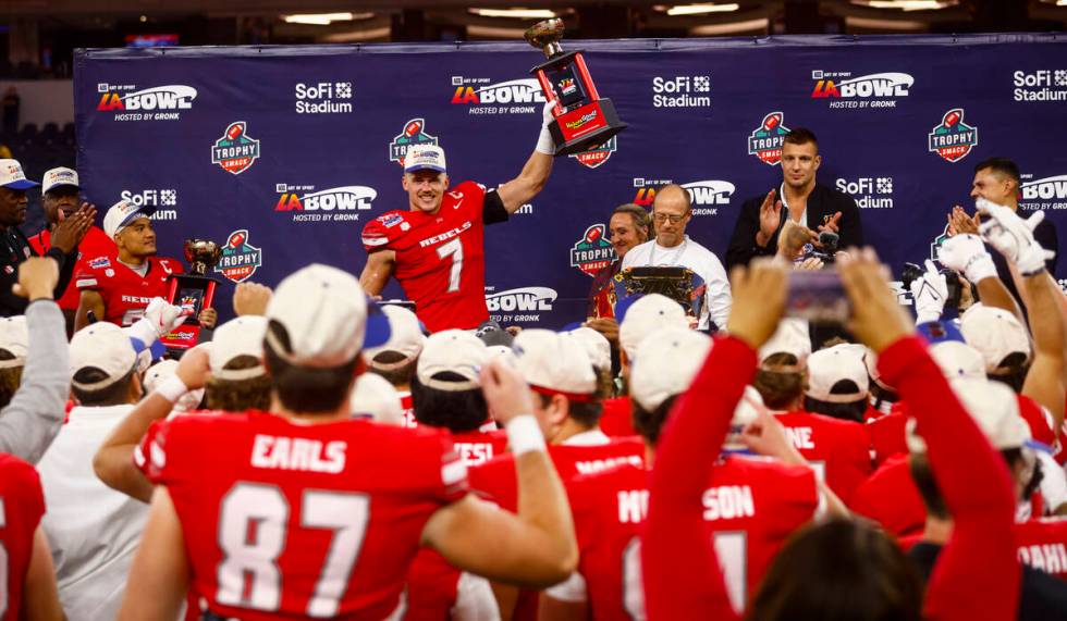 UNLV linebacker Jackson Woodard (7) lifts the trophy for best defensive player in the LA Bowl a ...