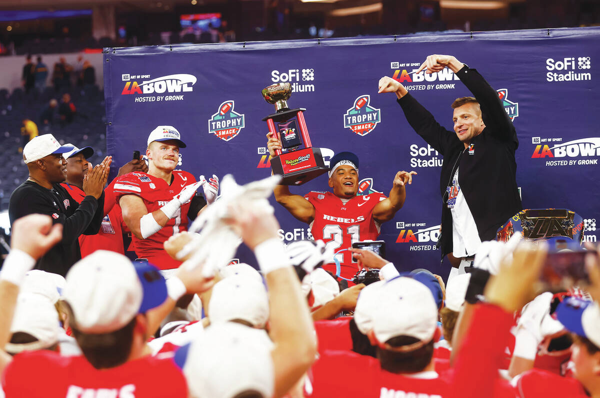 UNLV wide receiver Jacob De Jesus (21) lifts the trophy for offensive player of the game in the ...