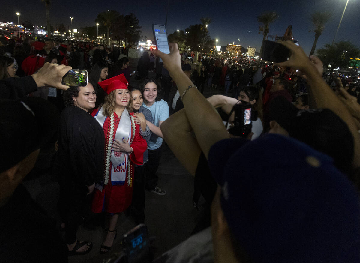 Graduates take photographs with family and friends after the UNLV winter commencement at the Th ...