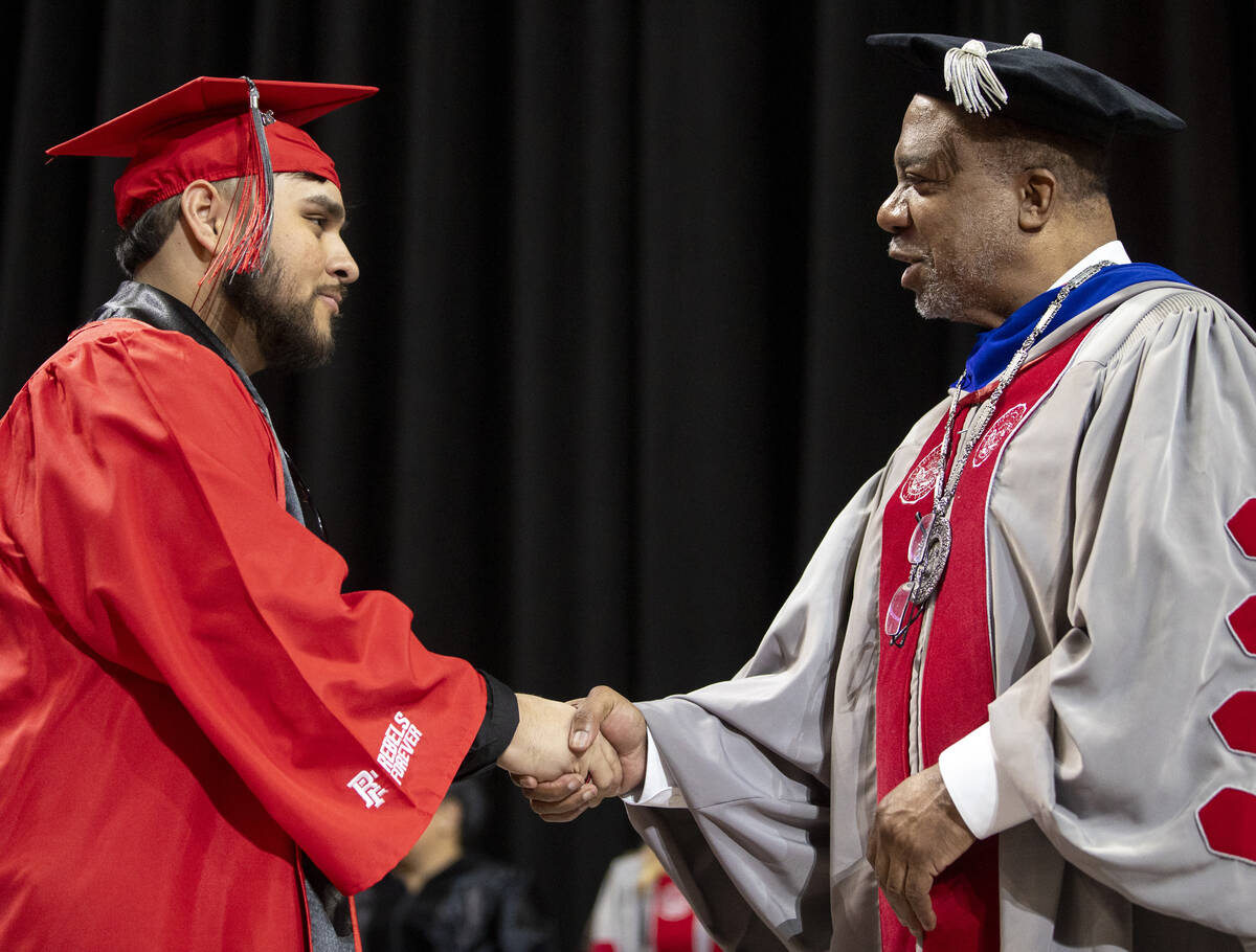 A graduate shakes hands with UNLV President Keith Whitfield, right, during the UNLV winter comm ...