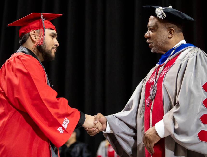 A graduate shakes hands with UNLV President Keith Whitfield, right, during the UNLV winter comm ...