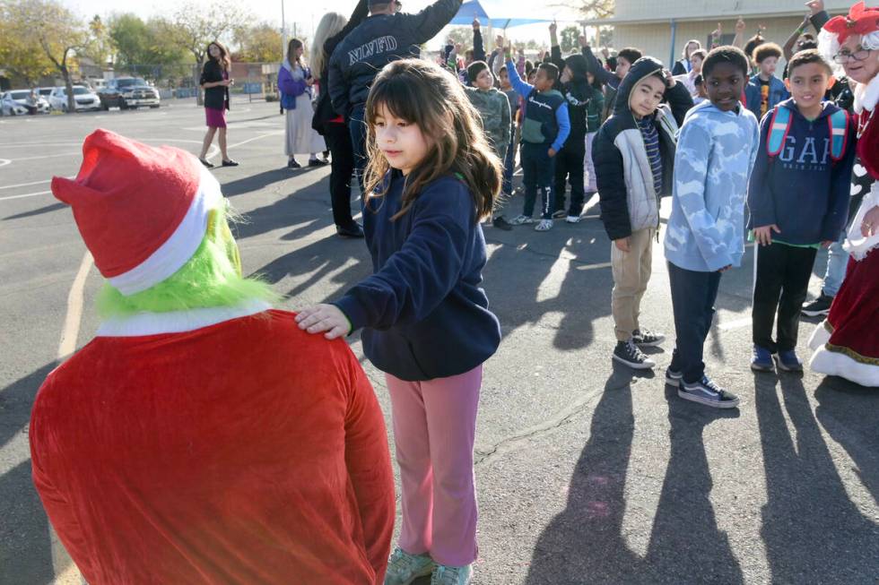 Nevaeh Armenta pats the Grinch on the shoulder while telling him, “Don’t steal Christmas. C ...