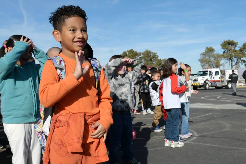 Julian Antnunez waves as firefighters arrive to deliver toys at Beckley Elementary School Thurs ...