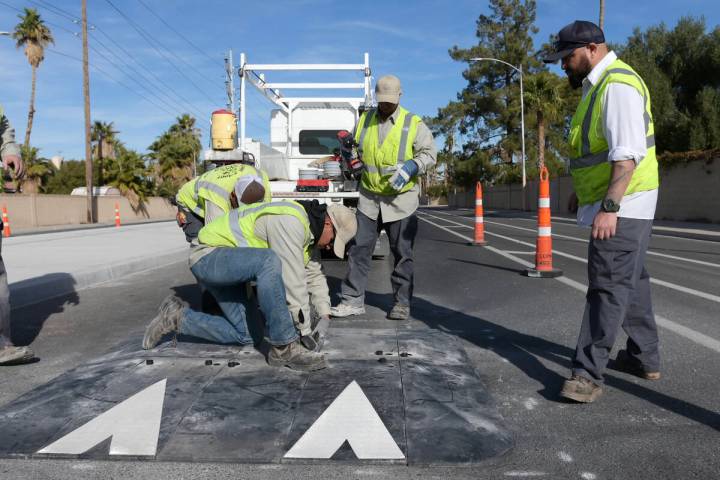 Workers from Clark County Public Works install speed humps near the intersection of Lamb Boulev ...