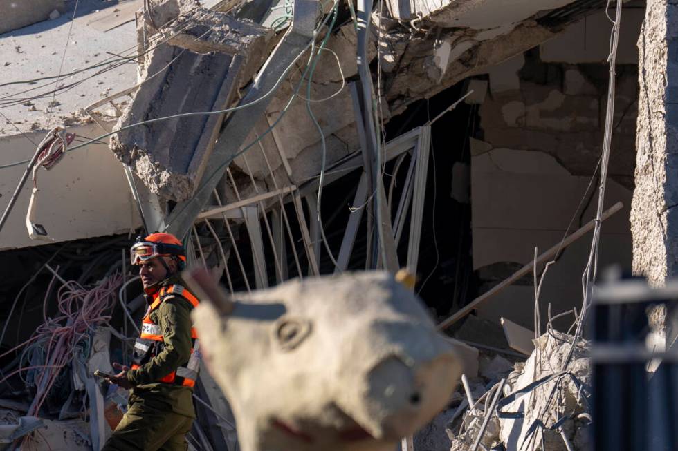 An officer from the home front command military unit examines the damaged after a large piece o ...