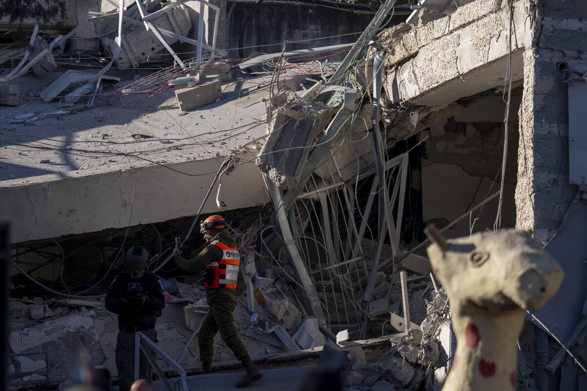 An officer from the home front command military unit examines the damage after a large piece of ...