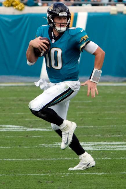 Jacksonville Jaguars quarterback Mac Jones looks for a receiver during the first half of an NFL ...