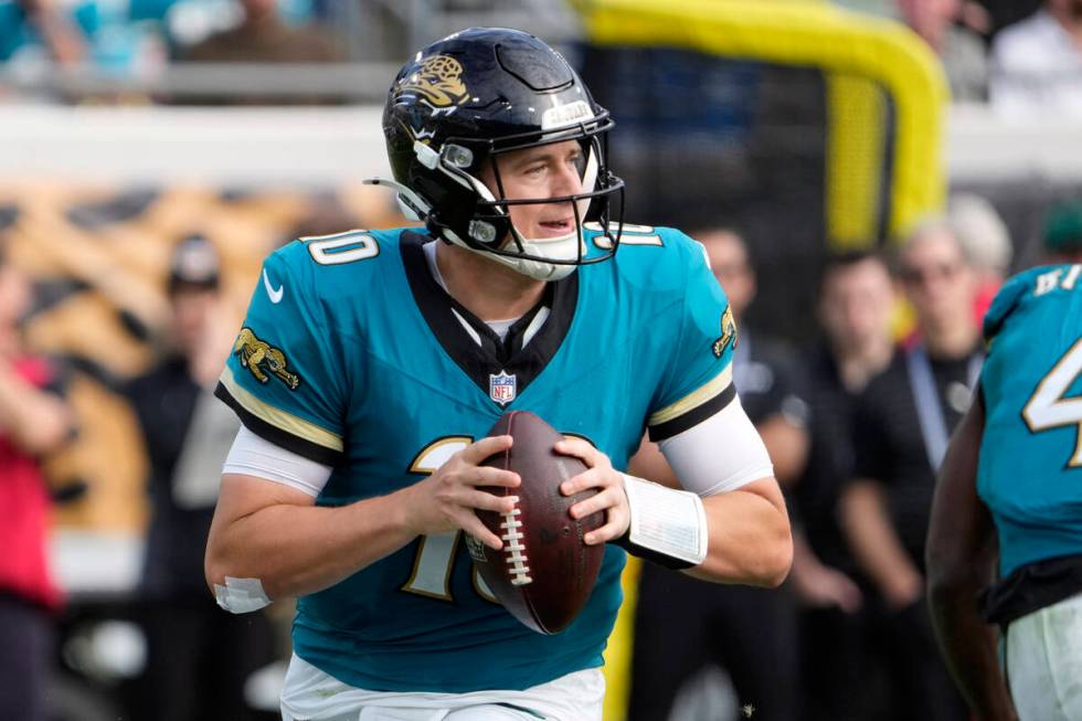 Jacksonville Jaguars quarterback Mac Jones (10) looks for a receiver during the second half of ...