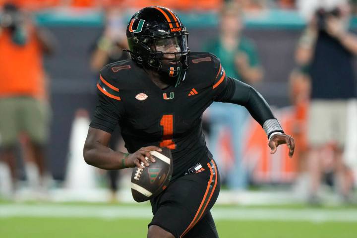 Miami quarterback Cam Ward (1) looks to pass during the first half of an NCAA college football ...