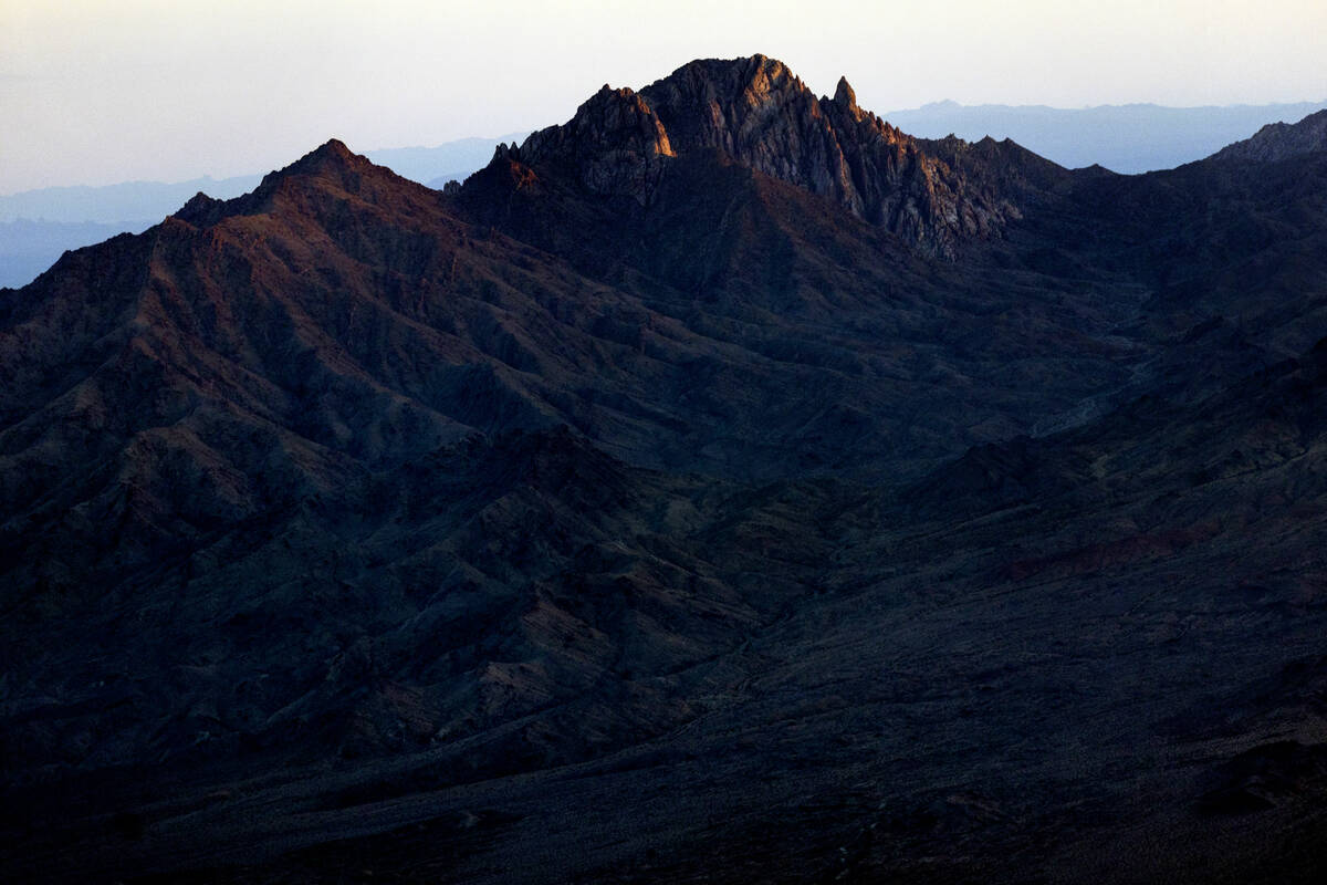 Light etches the peak of Spirit Mountain on Feb. 13, 2023, in Boulder City as the sun sets on t ...