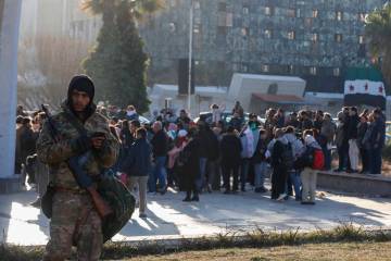 A Syrian fighter stands guard as activists gather at the Umayyad square during a protest to dem ...