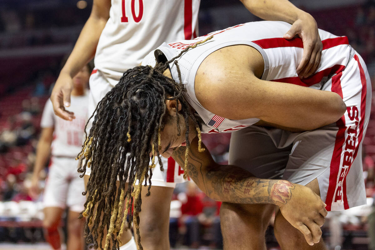 UNLV forward Jeremiah Cherry, right, holds his side after taking a hit during the first half of ...