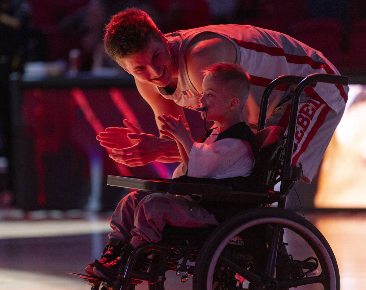 UNLV guard Julian Rishwain (20) and a member of Hoop.Camp cheer as more Runnin’ Rebel pl ...