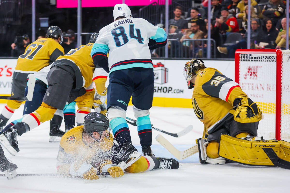 Golden Knights defenseman Zach Whitecloud (2) falls on the ice as the Kraken try to score durin ...