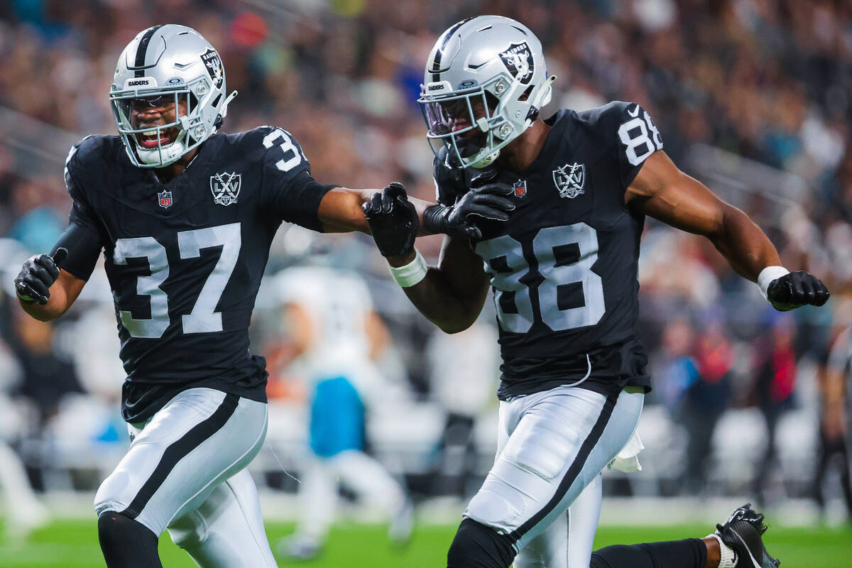 Raiders safety Trey Taylor (37) and Raiders tight end Justin Shorter (88) cheer as they run bac ...